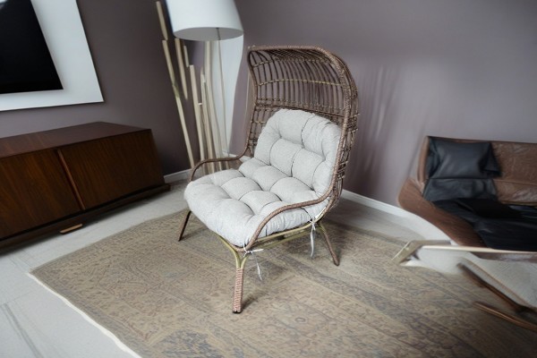 How does the ergonomic design of the iron rattan bird's nest chair improve the sitting experience?