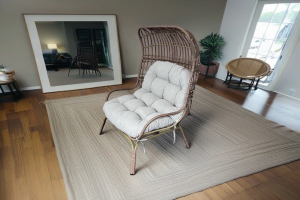How does the unique design of the iron rattan bird's nest chair add an artistic touch and a natural feel to your home?